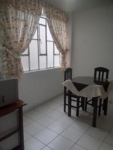 ein Esszimmer mit einem Tisch, Stühlen und einem Fenster in der Unterkunft Casa-Posada in Cajamarca