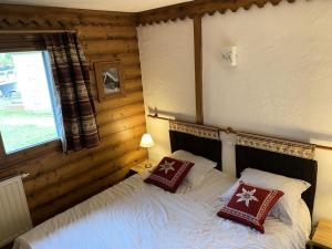sypialnia z łóżkiem i dwiema poduszkami w obiekcie Résidence La Ginabelle - maeva Home - Appartement 3 pièces 6 personnes - Sélection MAE-2964 w Chamonix-Mont-Blanc