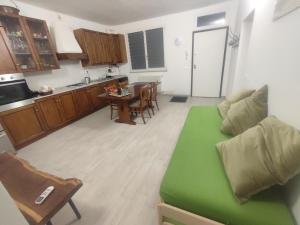 sala de estar con sofá verde y cocina en Alloggio Oltrepó, 