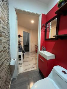 a bathroom with a red wall and a white sink at La Puerta Blanca #5 in Puerto Vallarta +12 photos
