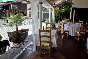 a restaurant with white tables and chairs and a plant at Hotel Sporn in Radomlje