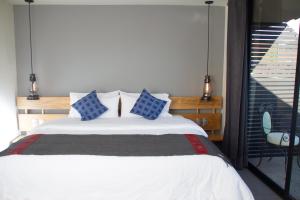 1 dormitorio con 1 cama con almohadas azules y blancas en Hotel Helverica, en San Cristóbal de Las Casas