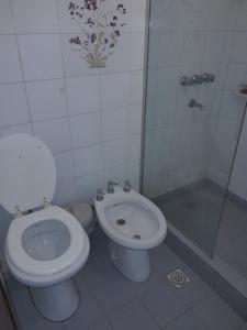 a white bathroom with a toilet and a shower at Cerro de las Rosas in Córdoba +2 photos