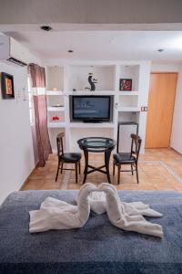 a living room with a table and a tv at Casa Playa Hermosa in Cancún