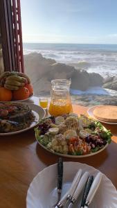 a table with two plates of food and a salad at Amaan ⴰⵎⴰⴰⵏ Cottage in Agadir