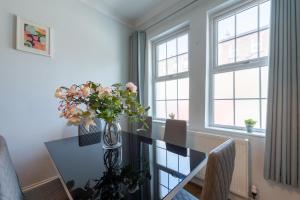 a dining room with a table with a vase of flowers at Spacious Comfy 2BR flat in London