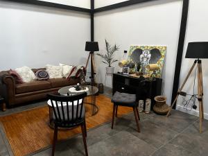 Hab. privada en Cité histórico del barrio Yungay في سانتياغو: غرفة معيشة مع أريكة وطاولة وكراسي