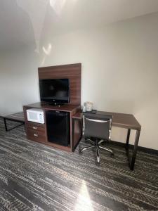 a desk with a television and a chair in a room at Clarion Pointe in Dillard