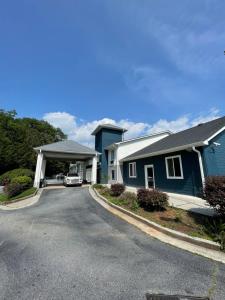 une maison bleue avec une voiture garée dans l'allée dans l'établissement Clarion Pointe, à Dillard