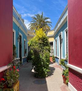 eine Reihe farbenfroher Häuser mit einer Palme im Hintergrund in der Unterkunft Hab. privada en Cité histórico del barrio Yungay in Santiago