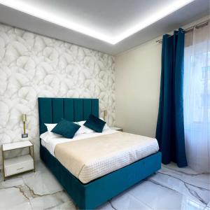a bedroom with a blue bed and blue curtains at Napoli Central Suites in Naples