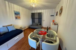 a living room with a glass table and a couch at Nice studio near the sea "La brise marine" in Trouville-sur-Mer