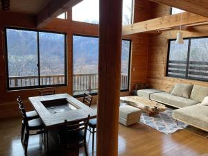 a living room with a table and a couch at WAKURABA- Chalet with the best views in Hakuba! in Hakuba