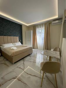 una camera con letto, tavolo e sedie di Napoli Central Suites a Napoli