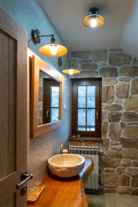 a bathroom with a sink and a stone wall at Guest Accommodation Butina in Kuterevo