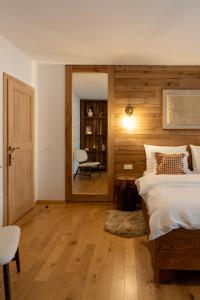 a bedroom with a bed and a chair and a mirror at Butina Guesthouse in Kuterevo