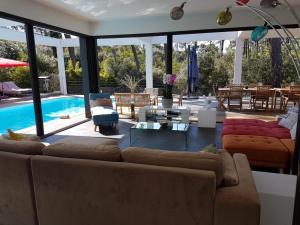 een woonkamer met een bank en een zwembad bij Villa CALIFORNIA Piscine chauffée 14x4m Abatilles Mouleau 10 pers in Arcachon