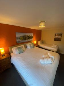 Royal Hotel في Dockray: غرفه فندقيه سريرين ومصباحين