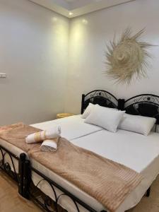 una camera da letto con un grande letto con lenzuola e cuscini bianchi di rise surf and yoga morocco ad Agadir