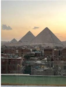 uma vista para as pirâmides de Gizé e uma cidade em Tapiri pyramids inn no Cairo