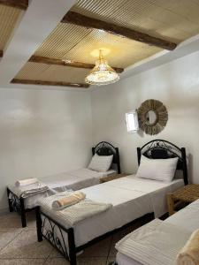 a room with two beds and a chandelier at rise surf and yoga morocco in Agadir