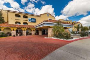 a hotel building with a red brick driveway at Best Western Moreno Hotel & Suites in Moreno Valley