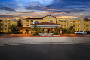 Un gran edificio con una fuente en un estacionamiento. en Best Western Moreno Hotel & Suites, en Moreno Valley