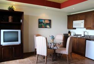 uma cozinha com uma mesa com cadeiras e uma televisão em Condo 117 Rivas-Gran Pacifica Resort (1 Bedroom) em San Diego