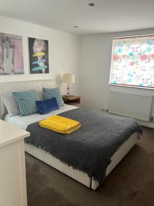 una camera da letto con un letto con una coperta gialla sopra di Gorgeous Cosy home 2 Miles from Heathrow Airport ad Ashford