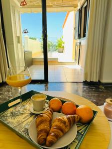 - une table avec une assiette de nourriture et un verre de vin dans l'établissement Los Gigantes Buenavista Ocean View Apartment, à Acantilado de los Gigantes