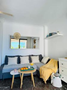 - un salon avec un canapé bleu et une table dans l'établissement Los Gigantes Buenavista Ocean View Apartment, à Acantilado de los Gigantes
