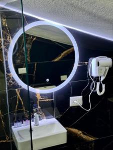 bagno con specchio e lavandino di VILA ALIZEE Hotel a Tirana