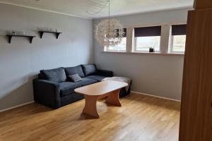 a living room with a couch and a table at Vágur, Home with a View in Vágur