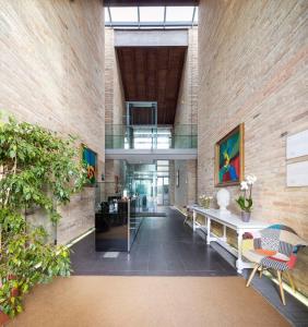 a lobby of a building with a large brick wall at Best Western Hotel Green City in Parma