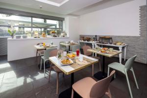 a restaurant with tables and chairs with food on them at Best Western Hotel Green City in Parma