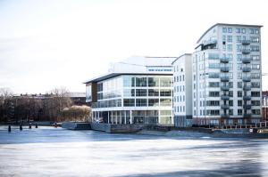 ein großes Gebäude neben einem gefrorenen Fluss mit Gebäuden in der Unterkunft Best Western Hotel River C in Karlstad
