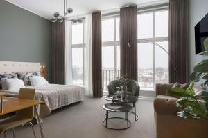 Best Western Hotel River C في كارلشتاد: غرفة نوم بسرير واريكة وطاولة