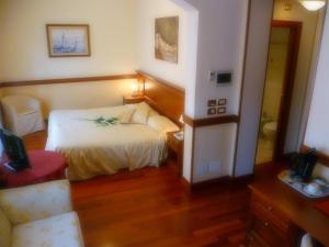 una camera con un letto e una sedia di Hotel Minerva a Pordenone