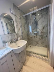een badkamer met een wastafel en een douche bij Bumblebee Barn, Luxury contemporary holiday home in Perranporth