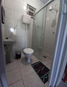 a bathroom with a toilet and a glass shower at Hosthê compartilhados in Canoas