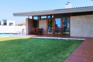 a house with a patio and a yard with grass at Chalet con piscina cerca de playas de Vigo in Vigo