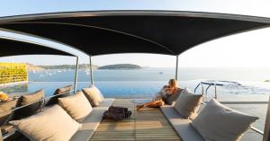 a woman sitting on a couch on a boat at Villa Thousand Cliffs in Nai Harn Beach