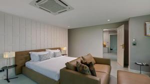a bedroom with a large bed and a couch at Villa Thousand Cliffs in Nai Harn Beach