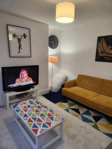a living room with a couch and a tv at Oval Cricket Ground walking distance in London