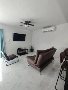 sala de estar con sofá y TV de pantalla plana en Pent-house a media cuadra del malecón, Hookipa Tower!, en Mazatlán