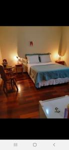 ein Schlafzimmer mit einem Bett und einem Tisch mit einem Stuhl in der Unterkunft Pousada As Relíquias de Minas in Tiradentes