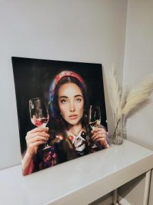 a picture of a woman holding two glasses of wine at Skyline Panorama Residence Warsaw in Warsaw