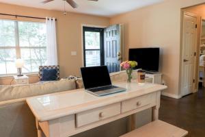 a living room with a laptop on a coffee table at Cozy Corner Cottage in Bentonville