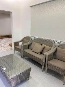 um grupo de cadeiras e mesas de vime numa sala em Liwan chalet - شاليه الليوان em Al Bukayriyah