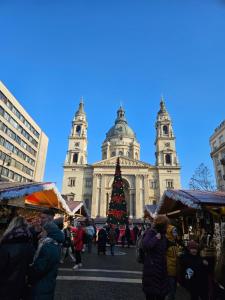 a christmas market in front of a building with a christmas tree at Danube Bridge Apartments in Budapest